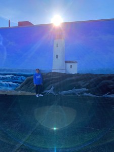Me standing by a lighthouse mural 