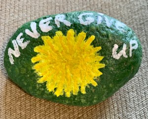 Dandelion painted rock with quote “Never Give Up”